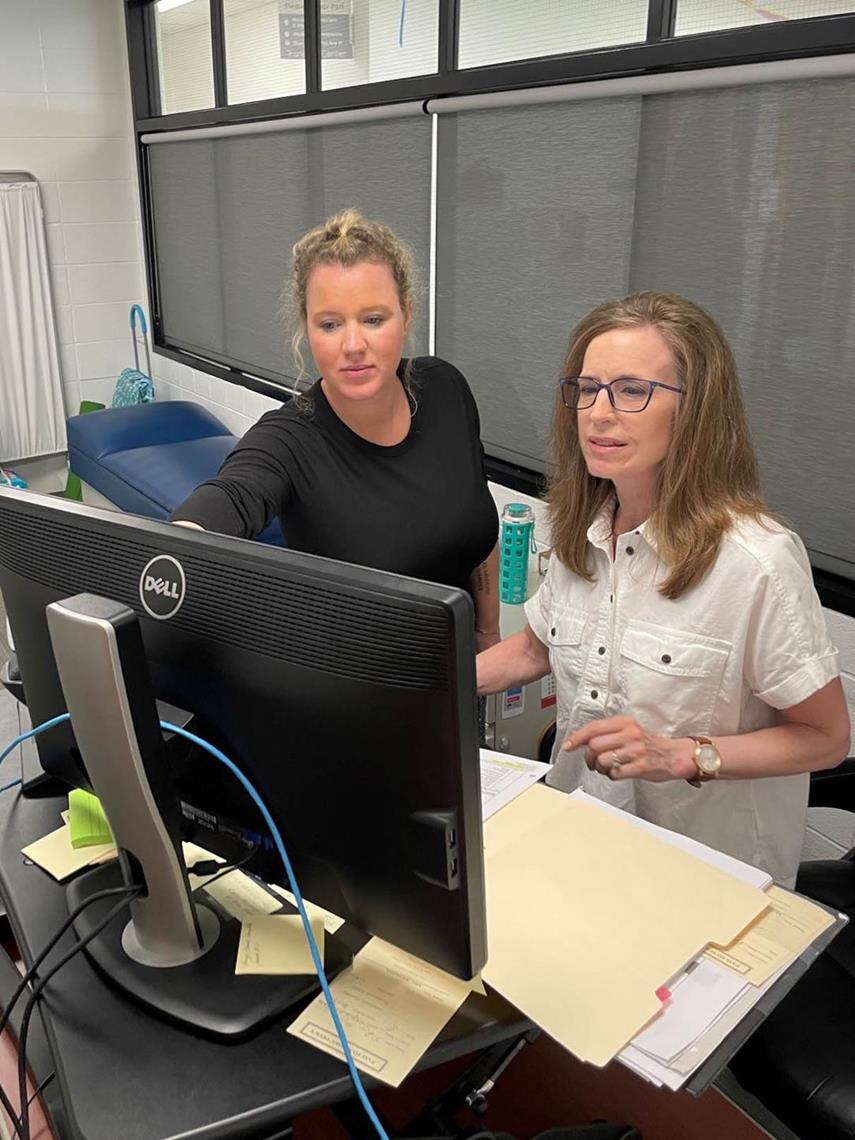 Two nurses viewing a computer screen in the MHS Transition Center Nurse's Office.