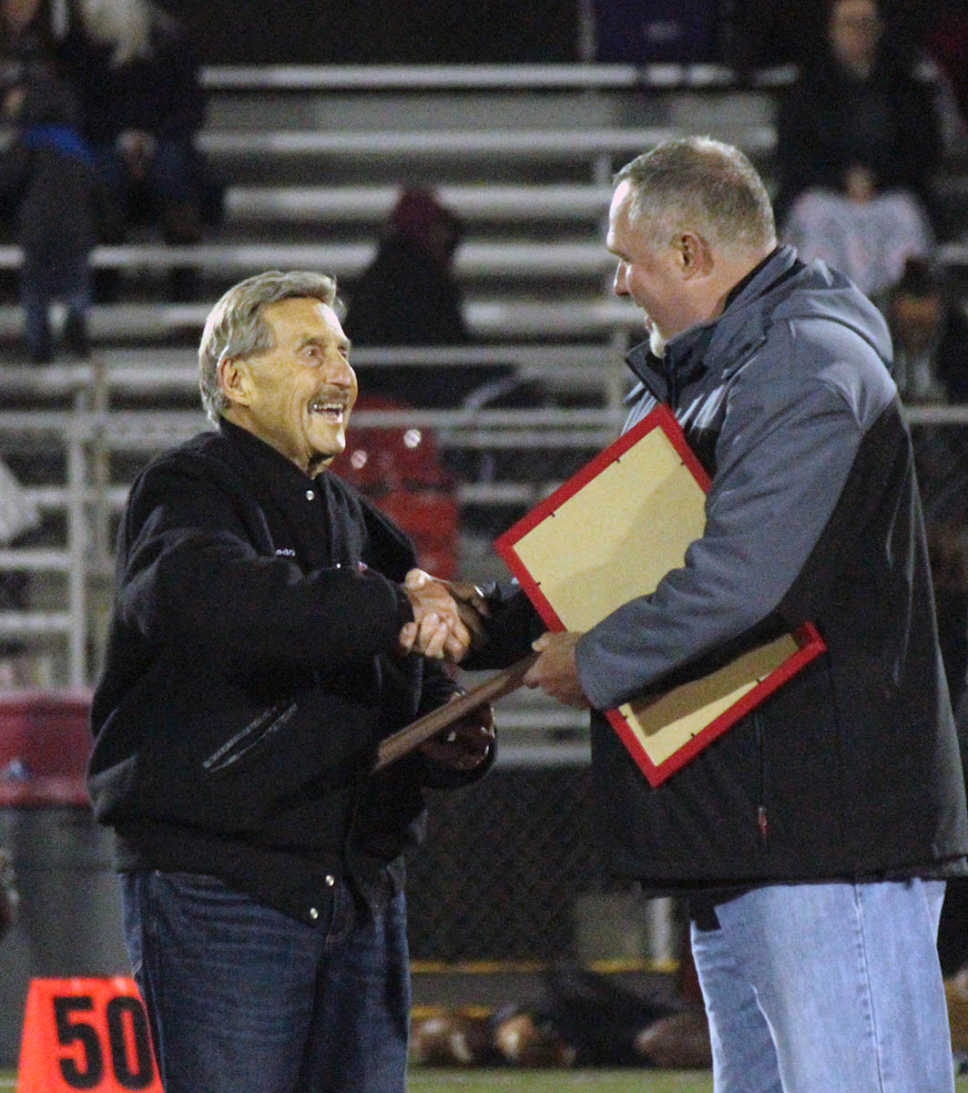 MHS Athletic Directory Troy Parola presents a plaque to former Football Coach Frank Giannamore