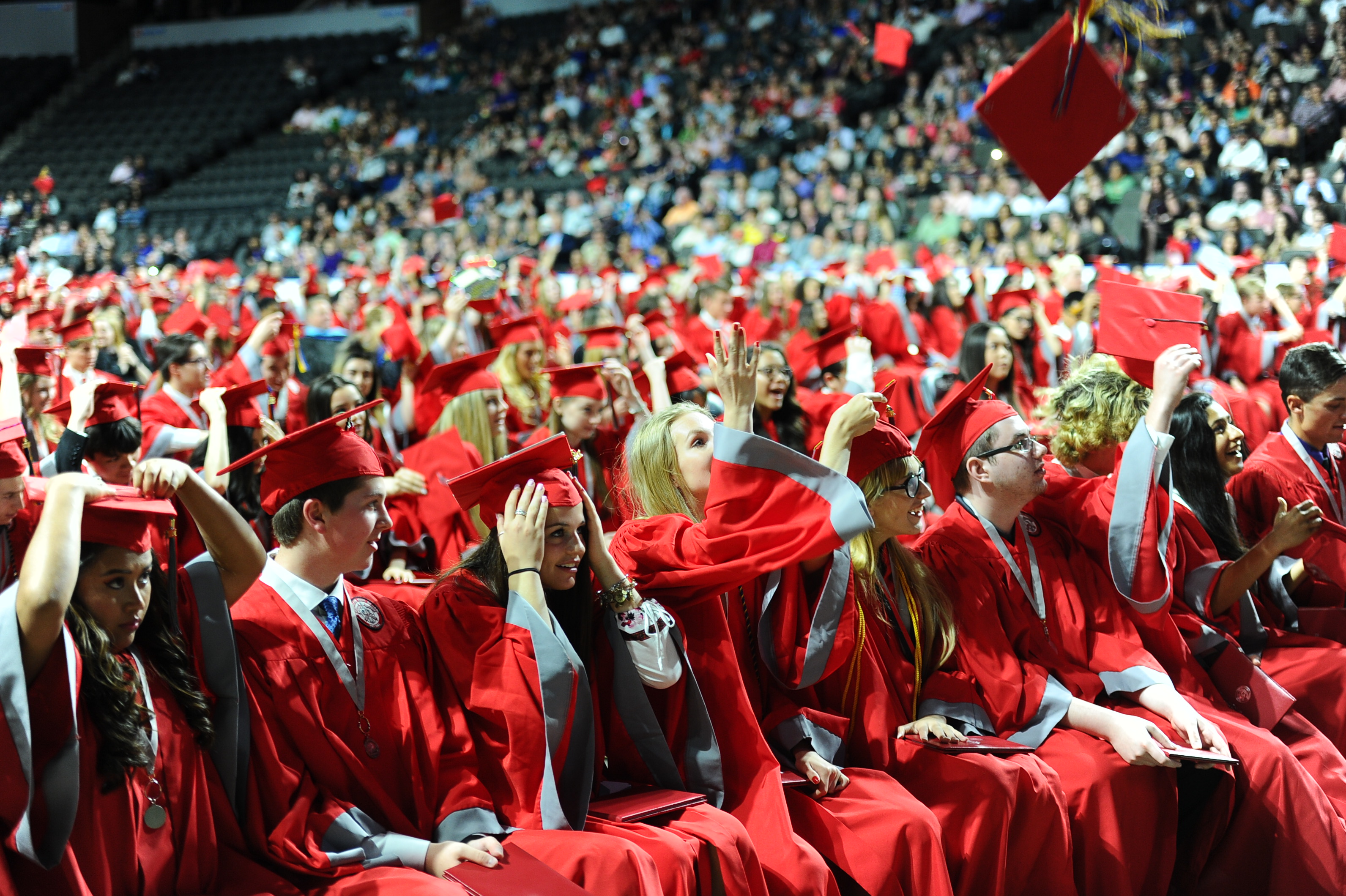 Photo from last year's graduation with graduates tossing their graduation caps in the air.