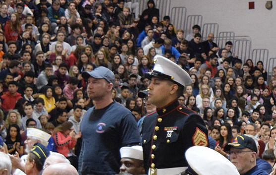 Two US Marines standing with the hundreds of attendees in the background