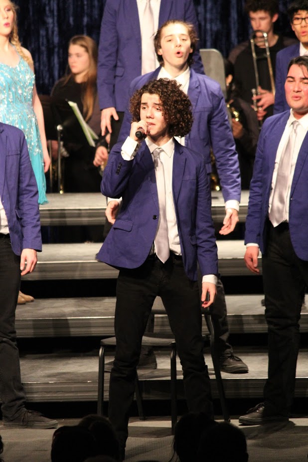 Matthew Callas holds the microphone while he performs a solo in competition
