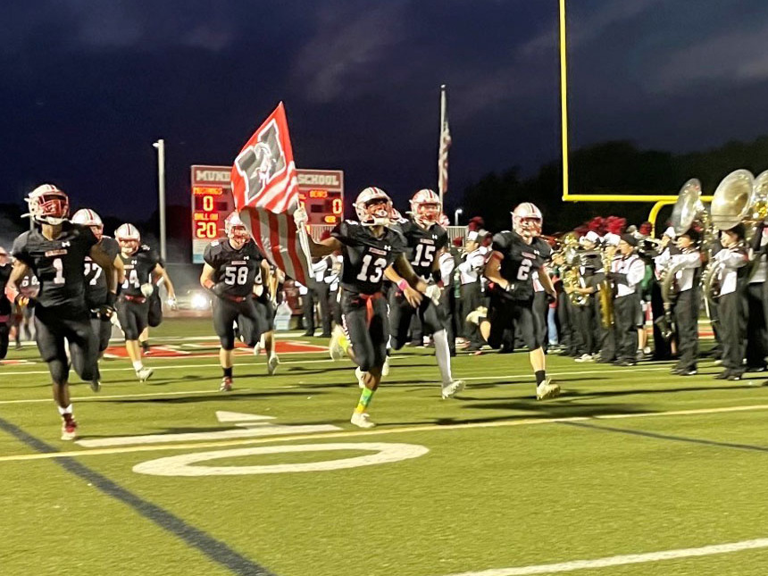 The MHS football program runs onto the field before a game in the October 2021.