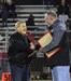 MHS Athletic Directory Troy Parola presents a plaque to former Football Coach Frank Giannamore