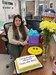 Joanna Rodriguez sits near flowers and a cake in honor of her award.