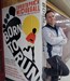 Ryan Buck standing in front of one of the English Hallway book murals
