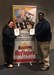 The two honorees standing in front of a banner for the magazine.