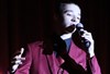 Male student singing into microphone during last year's variety show