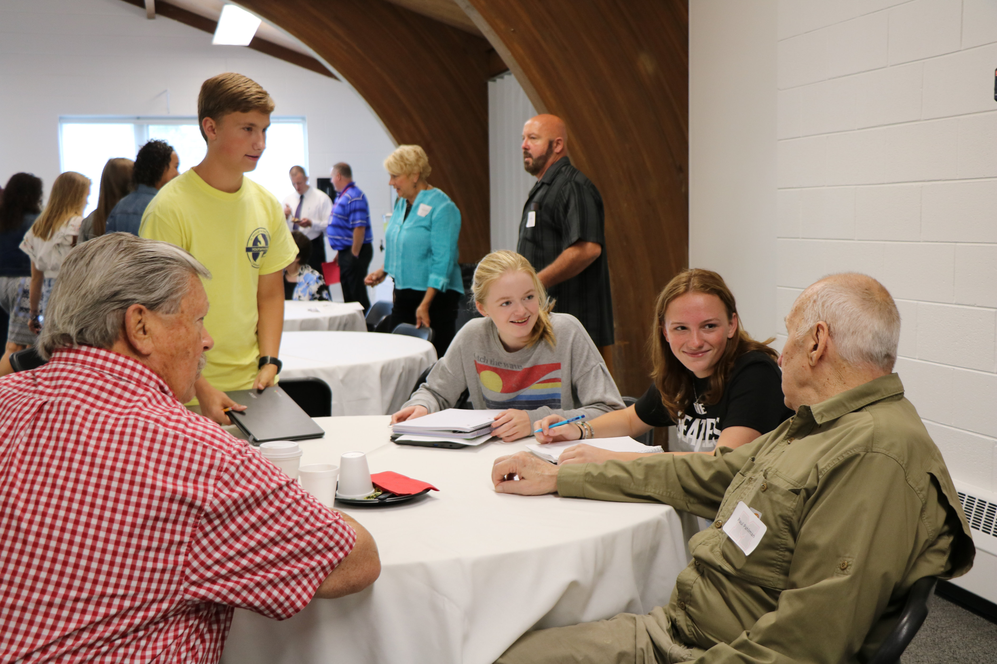 Retirees at breakfast being interviewed by student journalists