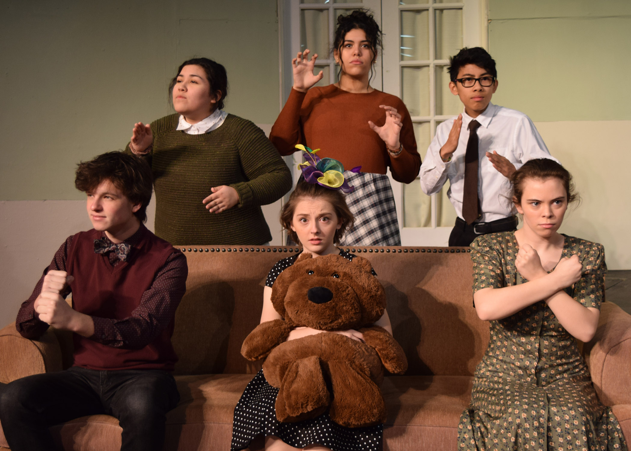 Six members of the cast posing with stuffed animals