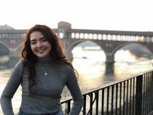 Photo of Carmen standing near historic landmark in Italy